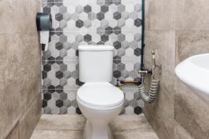 a bathroom with a toilet and a sink at Great 5BR Garden Inn by uBook in Butterworth +28 photos