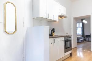 kuchnia z białymi szafkami i lodówką w obiekcie Spacious 2BR Apt -Near Wiener Stadthalle BurggasseWiener Well Located w Wiedniu +19 zdjęć