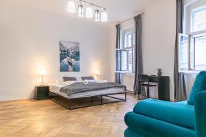 sypialnia z łóżkiem i niebieską kanapą w obiekcie Spacious 2BR Apt -Near Wiener Stadthalle BurggasseWiener Well Located w Wiedniu