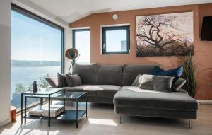 a living room with a couch and large windows at 4 Bedroom Gorgeous Home In Sætre in Sætre