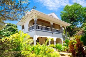 a white house with a balcony at Maison Ed-Elle in La Digue