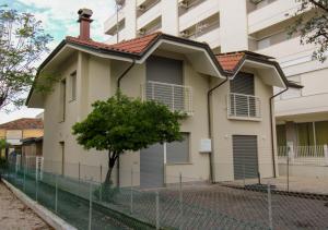 une maison avec une clôture devant un bâtiment dans l'établissement 62 Villa Vespucci Evangelisti Casa, à Bellaria-Igea Marina