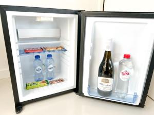 Un refrigerador abierto con botellas de agua y leche. en Wijnkopershuis Hendricksz, en Ámsterdam