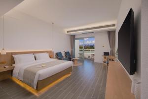 景洪市Yumu Hotel Gaozhuang Starlight Night Market Branch的一间配有床和平板电视的酒店房间