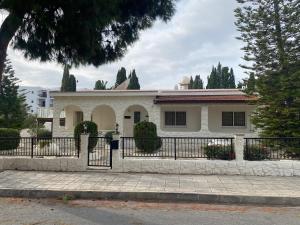 una casa blanca con una valla delante en villa 58 coral bay seafront, en Peyia
