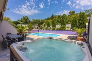 a large swimming pool with a table and chairs next to it at House Moderna 2 in Crikvenica