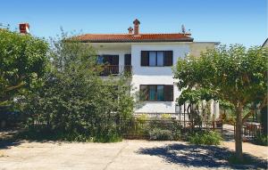 Biały dom z płotem przed nim w obiekcie Awesome Apartment In Umag With Wifi w mieście Umag