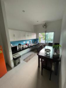 a kitchen with a wooden table and a dining room at Phangan Guest House in Thong Sala