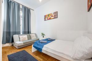 Un dormitorio blanco con una cama y un sofá. en M&M Apartment - Ferenciek tere, en Budapest