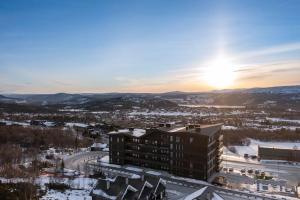 a view of a building with the sunset in the background at Riddertunets stilfulle in Beitostøl