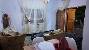 a living room with a table and chairs and a window at residence Musango la paix in Douala +28 photos