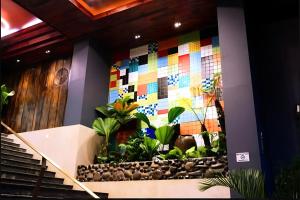 Un vestíbulo con una pared de mosaico de colores en Happy Life Green Hotel, en Ho Chi Minh