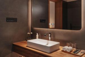 a bathroom with a white sink and a mirror at 峨眉山和院一溪清音酒店 in Emeishan City