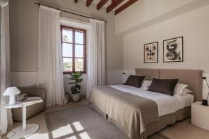 a bedroom with a large bed and a window at Cal Reiet Holistic Retreat in Santanyi