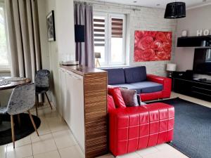 a living room with a red chair and a couch at Dom na Leszczynowej Górce - plaża, las in Ełk