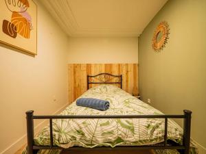 a small bedroom with a bed with a wooden headboard at L'Évasion Sauna & Spa in Saint-Rambert-dʼAlbon