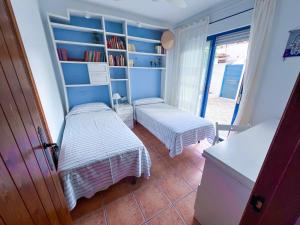 a bedroom with two beds and a book shelf at La Casita Azul in San José