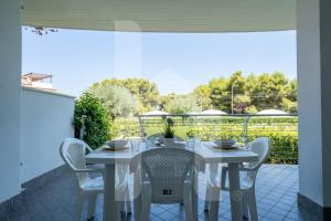 a white table and chairs on a patio at Homiday - Residence Mykonos in Pineto