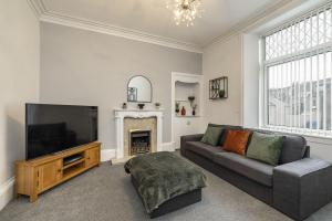 a living room with a couch and a television at Old Mart View in Hawick