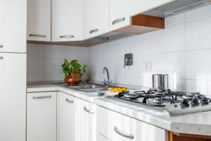a kitchen with white cabinets and a stove top oven at I Pungenti in Castiglioncello
