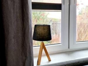 a lamp sitting on a table next to a window at Dom na Leszczynowej Górce - plaża, las in Ełk