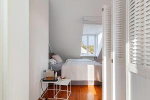 Un dormitorio blanco con una cama y una ventana. en Skyline-Blick, en Bad Soden am Taunus