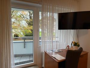a room with a desk and a large window at Komfort Appartement Bad Pyrmont Nähe Kurpark in Bad Pyrmont