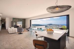 a kitchen and living room with a large window at Villa Bellagio avec vue exceptionnelle in Monticello