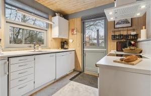a kitchen with white cabinets and a white counter top at Holiday Home Bøsholmstien Glesborg Denm in Fjellerup Strand