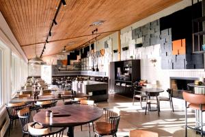 a restaurant with wooden ceilings and tables and chairs at Sirdalsvatnet Hotel in Sirdal in Tonstad