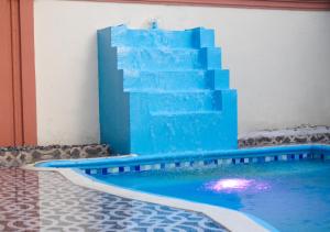 a swimming pool with a blue staircase in a building at Casa familiar con piscina y cerca de la playa in La Belleza