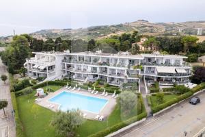 een luchtzicht op een groot wit herenhuis met een zwembad bij Homiday - Residence Mykonos in Pineto