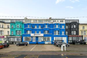 a blue building with cars parked in a parking lot at Bluewaters Hotel Blackpool in Blackpool