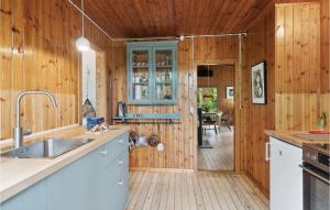 a kitchen with wooden walls and a wooden floor at 2 Bedroom Gorgeous Home In Jægerspris in Jægerspris
