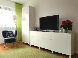 a living room with a television on a white cabinet at Wygodny dwupokojowy apartament pomiedzy lotniskiem a centrum in Warsaw