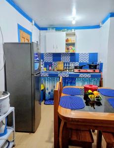 kuchnia ze stołem i lodówką w obiekcie Spacious Home with Beautiful View in Toril Proper w mieście Davao