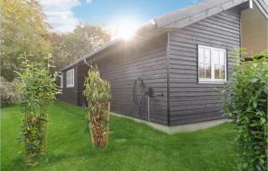 a black house with two trees in the yard at Awesome Home In Græsted With Wifi in Græsted +10 photos