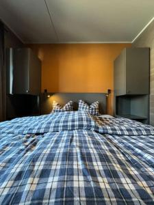 une chambre avec un lit avec une couverture à carreaux dans l'établissement Riddertunets hygge, à Beitostøl