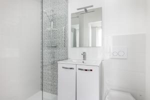 une salle de bain blanche avec lavabo et douche dans l'établissement STUDIOS cosy au centre-ville quartier Jaurès et Saint-Martin, à Brest