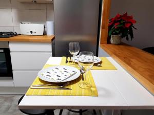 a white table with two glasses of wine on it at Wygodny dwupokojowy apartament pomiedzy lotniskiem a centrum in Warsaw +12 photos