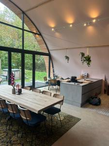 una cucina e una sala da pranzo con un tavolo di legno di Bosresort Maanzicht a Noordwolde Altre 30 foto