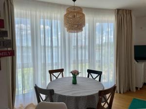 a dining room table with chairs and a vase of flowers at Apartment No 207 Lebada Lake Residence in Pantelimon