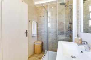 une salle de bain avec une douche en verre et un lavabo dans l'établissement Casa Baleeira - Modern apartment with Seaview, à Armação de Pêra