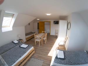 two beds in a room with a table and chairs at Kun Pista Vendégház III in Vértesboglár