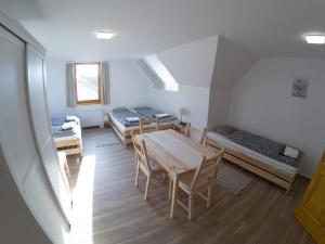 a room with three beds and a table and chairs at Kun Pista Vendégház III in Vértesboglár