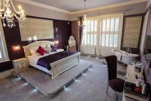 a bedroom with a large bed and a tub and a sink at Derby Manor in Bournemouth