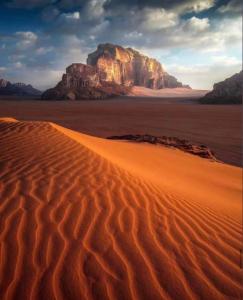 a desert with a mountain in the background at Bedouin cave wadi rum campsite in Wadi Rum +13 photos