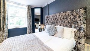 a bedroom with a white bed with a large window at Derby Manor in Bournemouth