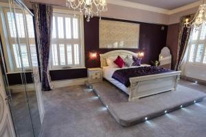 a bedroom with a bed and a chandelier at Derby Manor in Bournemouth