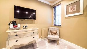a room with a dresser with a television on the wall at Derby Manor in Bournemouth